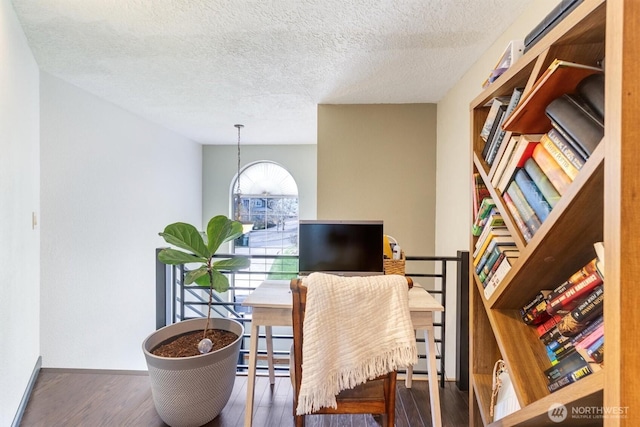 office space with wood finished floors, baseboards, and a textured ceiling