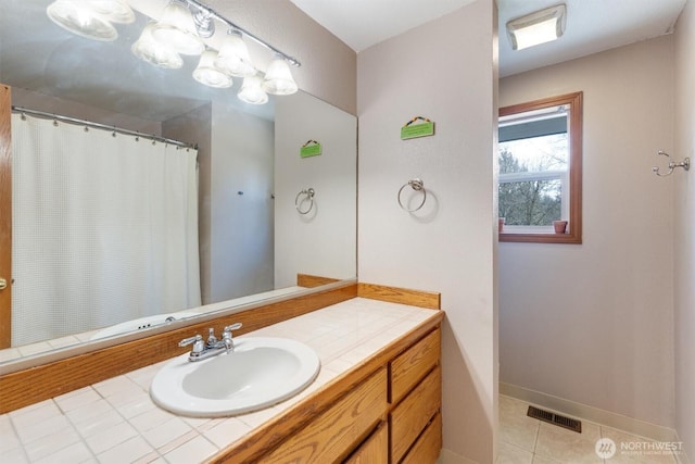 bathroom with vanity, a shower with curtain, baseboards, visible vents, and tile patterned floors