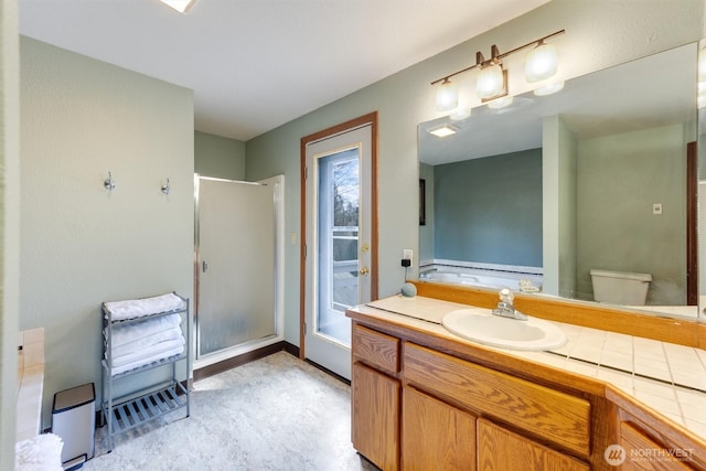 full bath featuring vanity, baseboards, and a stall shower