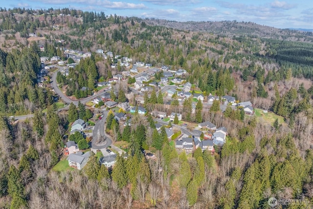 birds eye view of property featuring a residential view and a wooded view