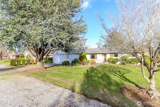 ranch-style house featuring driveway, an attached garage, a chimney, and a front yard