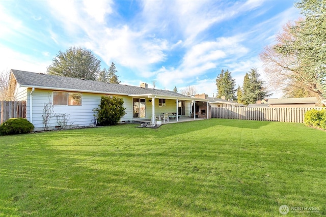 back of house with a patio area, a fenced backyard, a chimney, and a yard