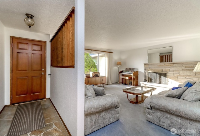 carpeted living area with a textured wall, a textured ceiling, and a stone fireplace