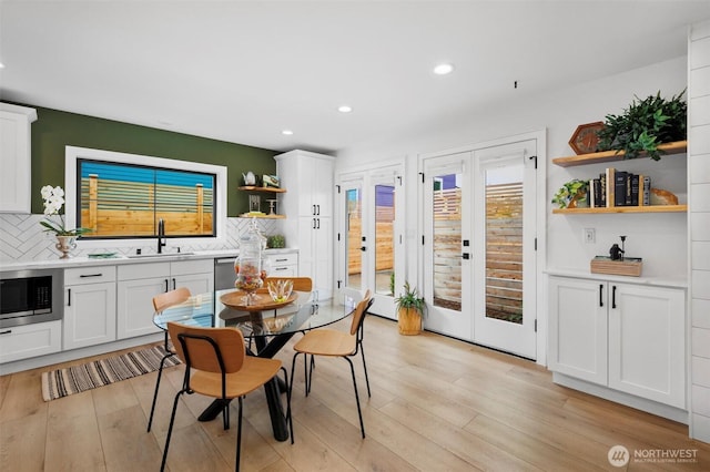 dining room with french doors, light wood finished floors, and recessed lighting