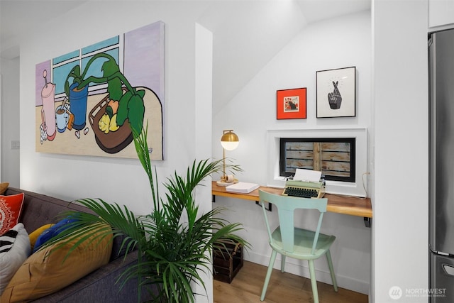 home office with lofted ceiling and wood finished floors