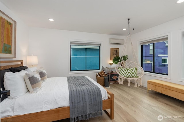 bedroom with a wall mounted AC, wood finished floors, and recessed lighting