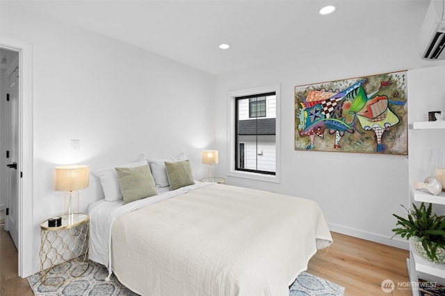 bedroom featuring baseboards, a wall mounted AC, wood finished floors, and recessed lighting