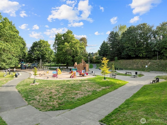 view of home's community with playground community and a yard