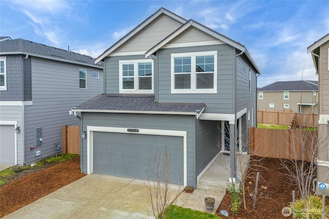 view of front of property featuring concrete driveway, an attached garage, fence, and a shingled roof