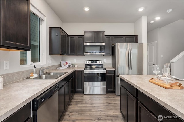 kitchen featuring a sink, light countertops, light wood-type flooring, and stainless steel appliances