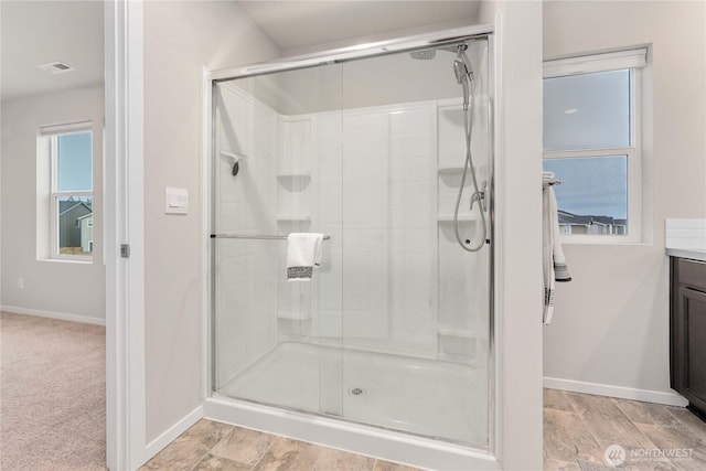 full bathroom with visible vents, baseboards, a stall shower, and vanity