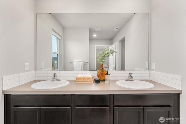 full bathroom featuring double vanity, visible vents, and a sink