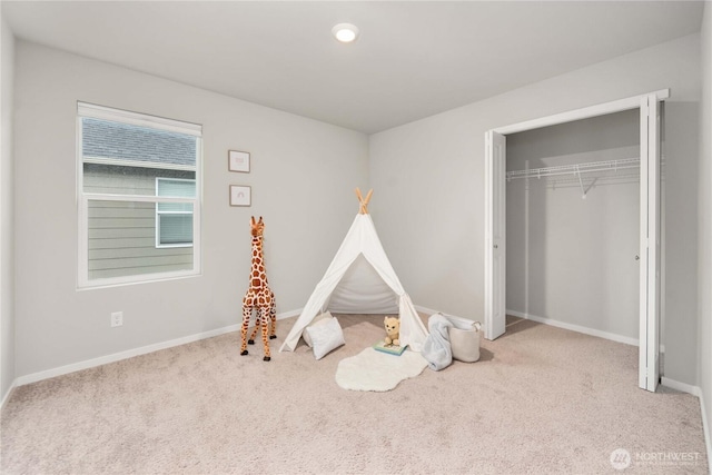 recreation room with baseboards and carpet flooring