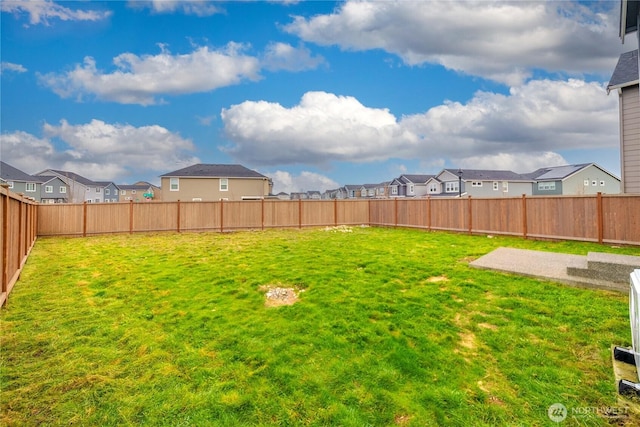 view of yard with a fenced backyard and a residential view