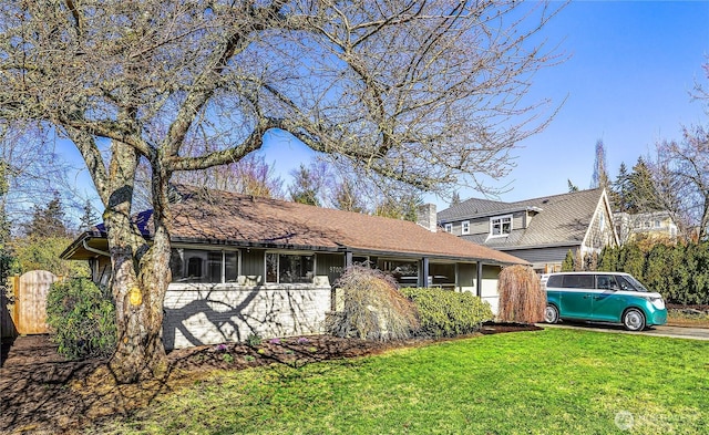 ranch-style house featuring a front lawn, fence, and a chimney