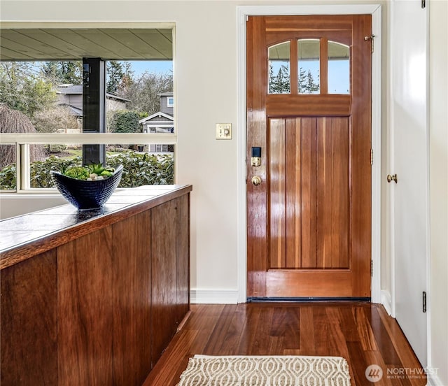 foyer featuring dark wood-type flooring and baseboards