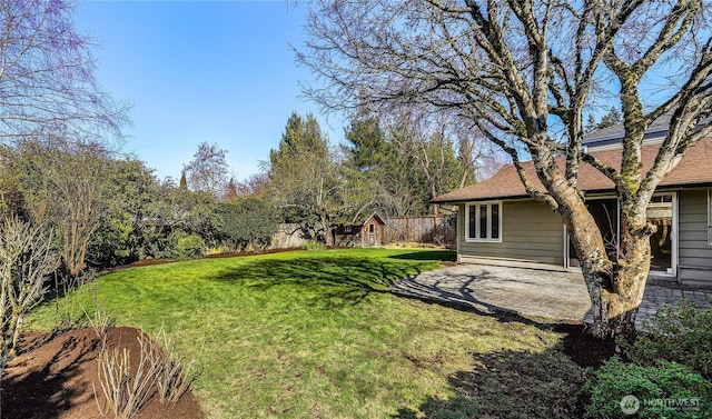 view of yard with a patio area, an outdoor structure, and fence