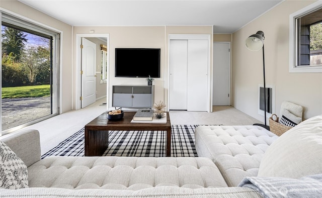 living area with a wealth of natural light, visible vents, and carpet