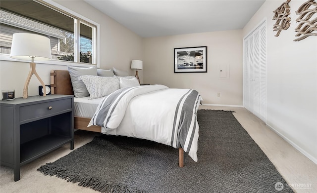 bedroom with light colored carpet and baseboards