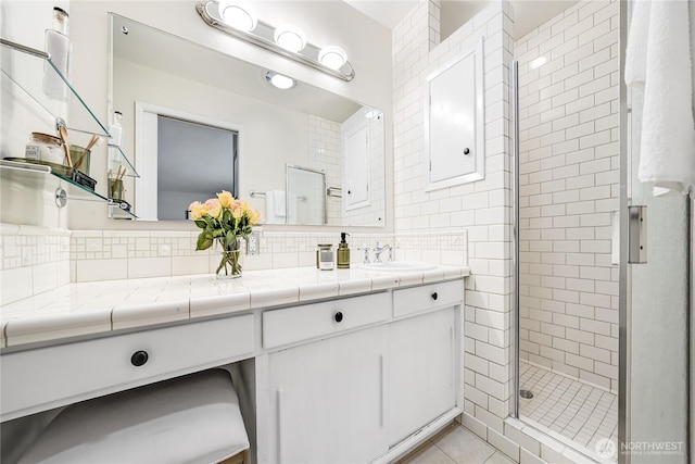 full bathroom featuring vanity, tile patterned floors, a stall shower, and backsplash