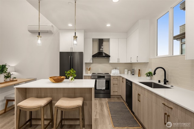 kitchen featuring black dishwasher, stainless steel electric stove, freestanding refrigerator, a sink, and wall chimney exhaust hood