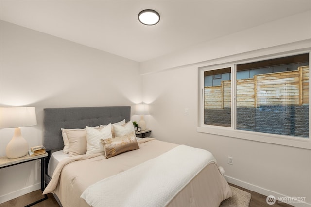 bedroom with baseboards and wood finished floors