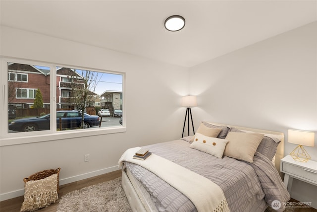 bedroom featuring baseboards and wood finished floors