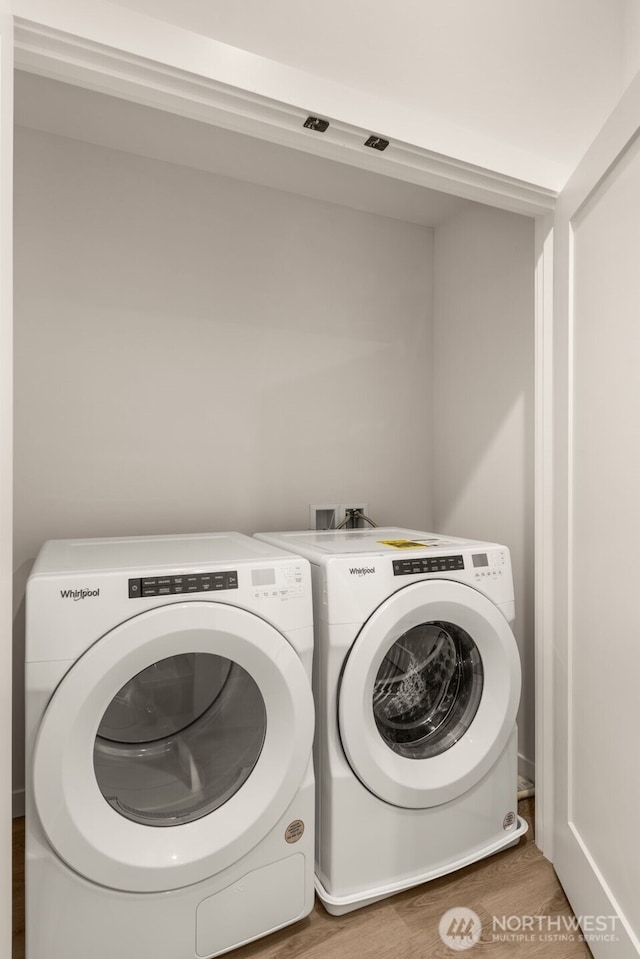 laundry area featuring laundry area, washing machine and dryer, and light wood-style floors