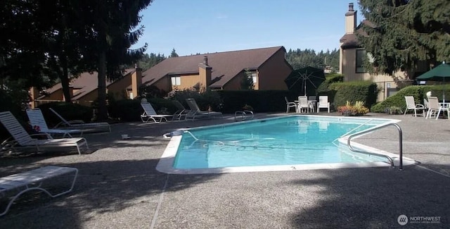 community pool featuring a patio and fence