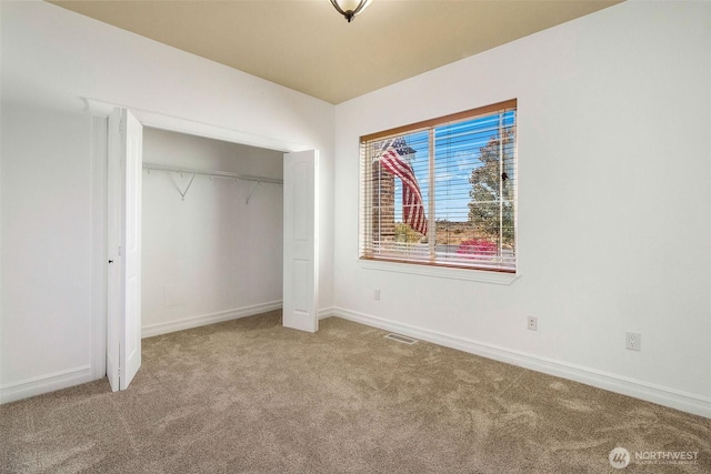 unfurnished bedroom featuring carpet floors, baseboards, visible vents, and a closet