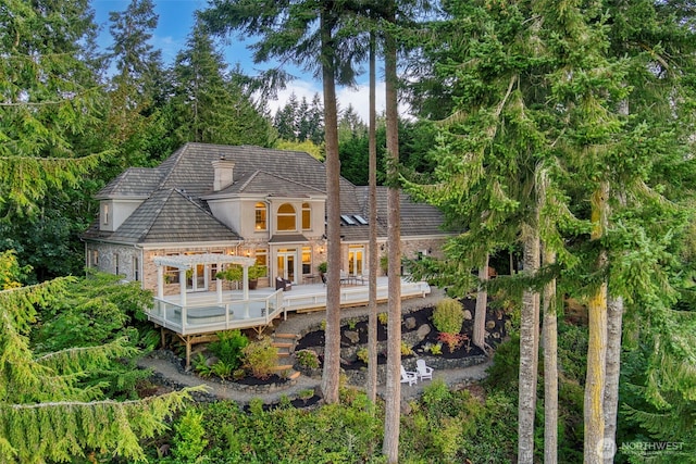 back of house with a deck, a pergola, and stucco siding