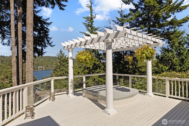 wooden deck featuring a water view, a forest view, and a pergola