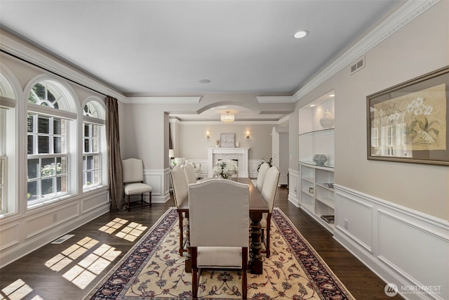 dining space featuring ornamental molding, visible vents, dark wood finished floors, and a decorative wall