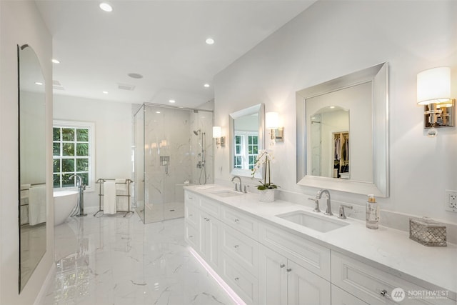 full bathroom with marble finish floor, a sink, a marble finish shower, and double vanity