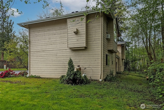 view of property exterior with a yard and fence