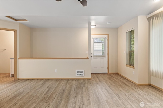 spare room with a ceiling fan, heating unit, wood finished floors, and baseboards