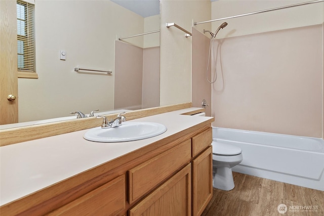 bathroom featuring bathtub / shower combination, toilet, wood finished floors, and vanity