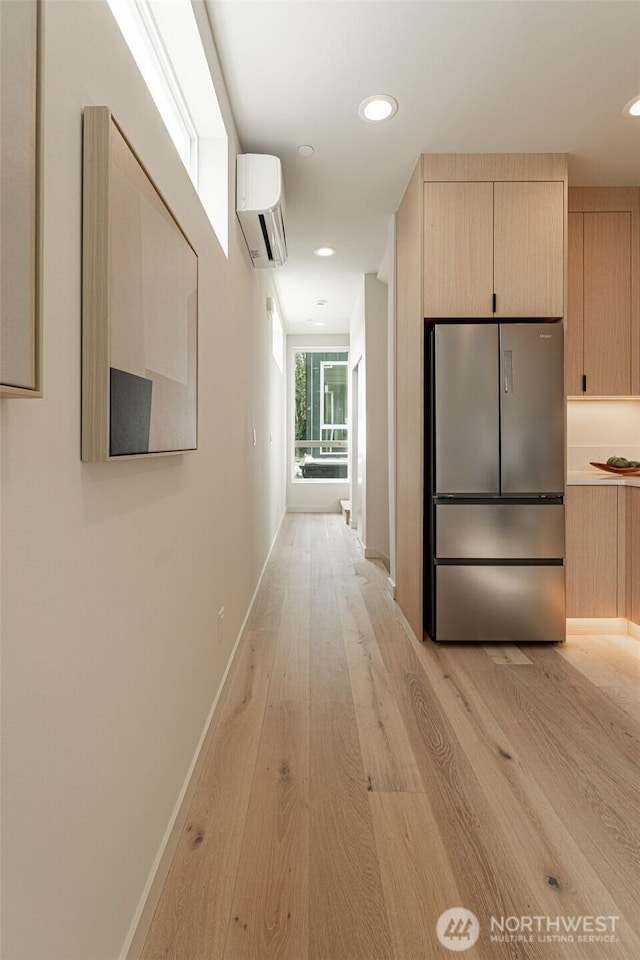 hallway with a wall mounted AC, recessed lighting, light wood-style flooring, and baseboards