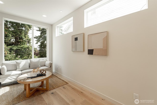 living room featuring light wood-type flooring, baseboards, and recessed lighting