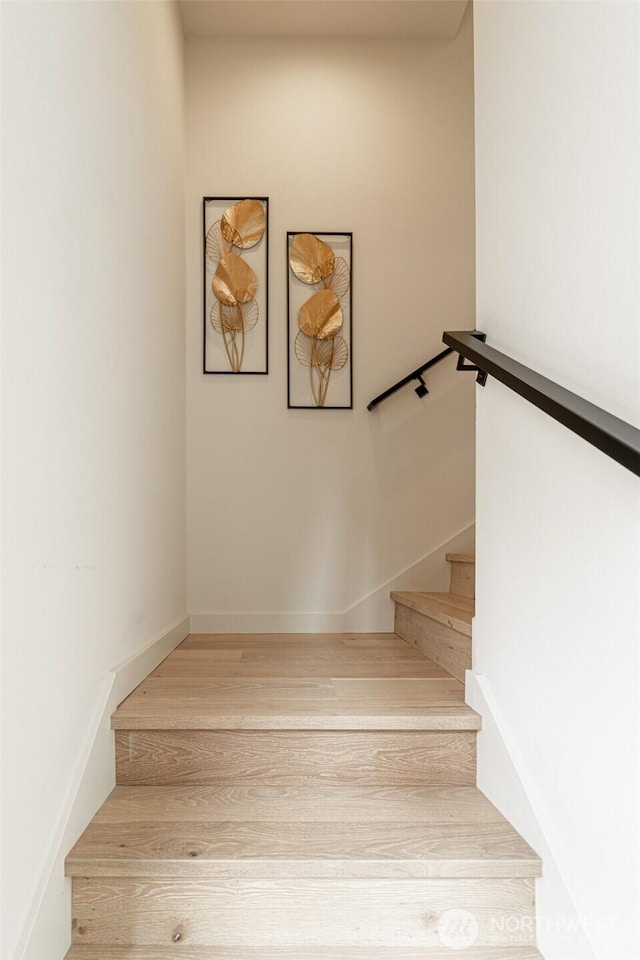 stairway with baseboards and wood finished floors