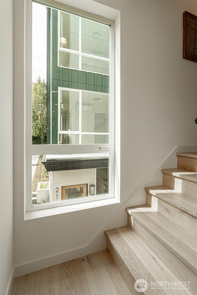 staircase with baseboards and wood finished floors