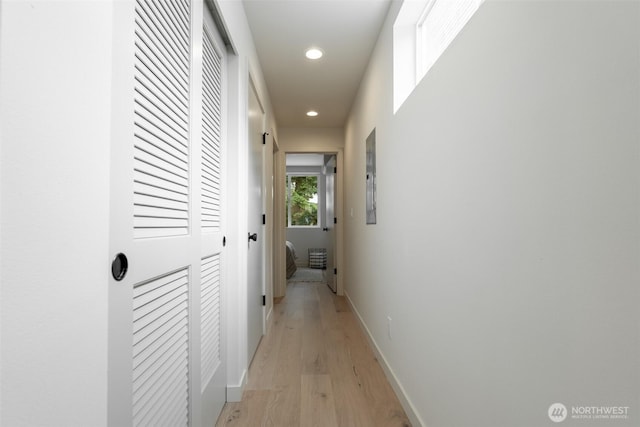 corridor featuring recessed lighting, light wood-style flooring, and baseboards