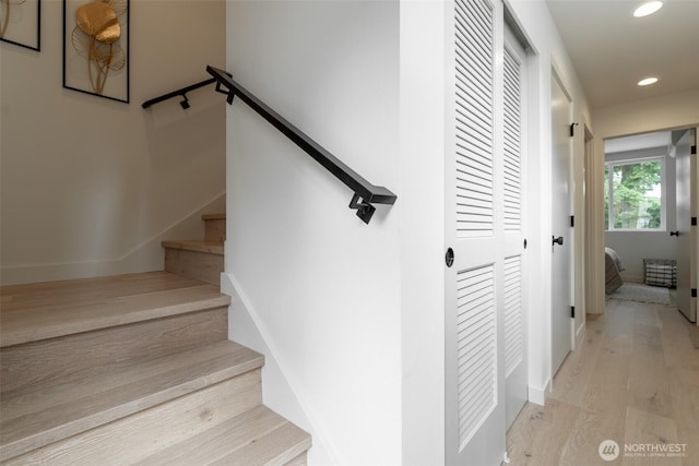 staircase with baseboards, wood finished floors, and recessed lighting