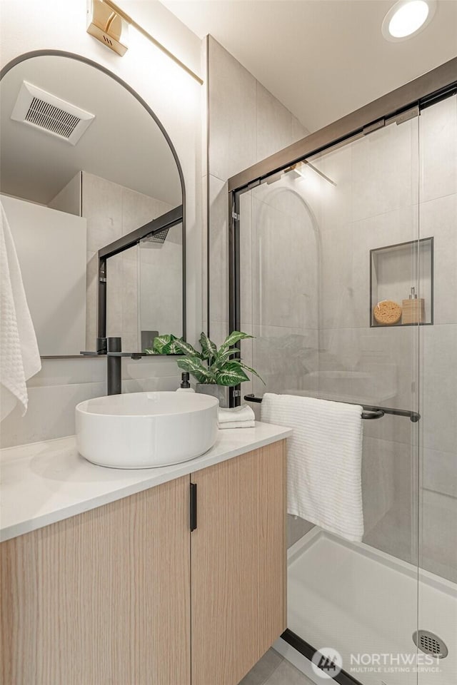 bathroom featuring a shower stall, visible vents, and vanity