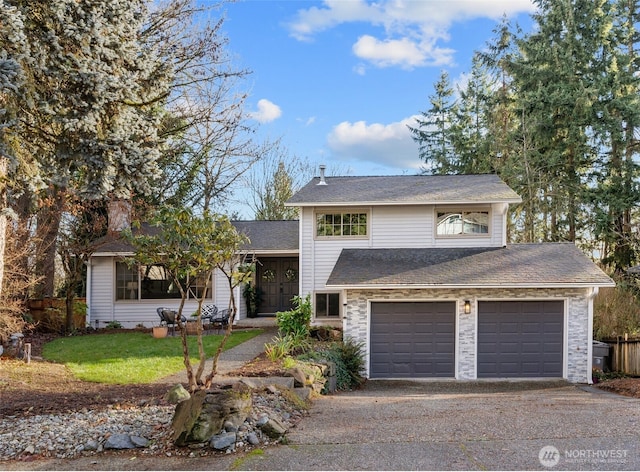 view of front of home featuring a garage, driveway, and fence