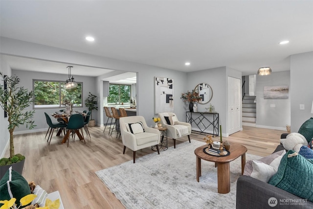 living area featuring light wood finished floors, stairway, recessed lighting, and baseboards