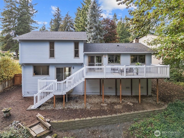 back of property with a shingled roof, fence, stairway, a chimney, and a deck