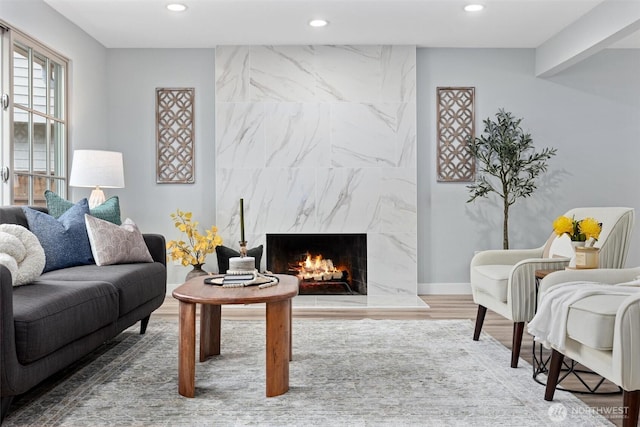 living area featuring recessed lighting, a premium fireplace, and wood finished floors