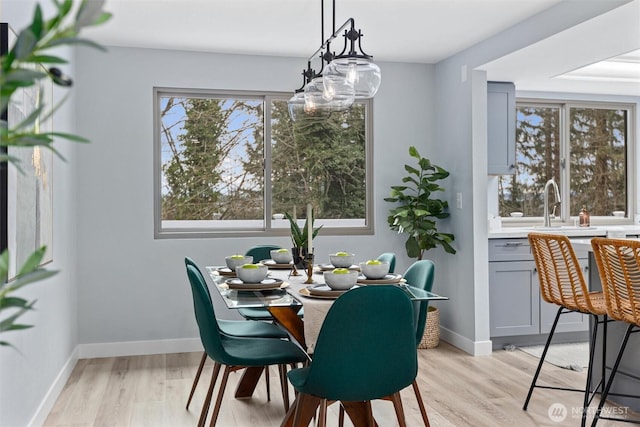 dining area featuring baseboards and light wood-style flooring