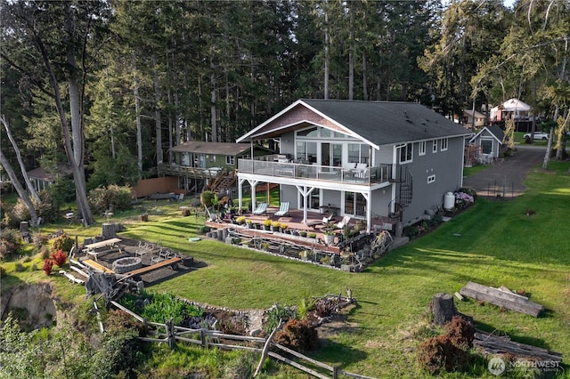 rear view of property featuring a lawn, stairway, and a wooden deck